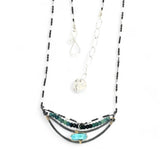 A darkened sterling silver crescent necklace  featuring a bright blue druzy quartz slab and ombre blue tourmaline gemstones on gold filled wire