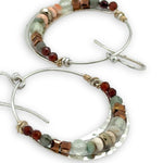 Sterling silver channel hoop earrings with a line of opal, pyrite, green amethyst, and hessonite garnet gemstones on gold filled wire