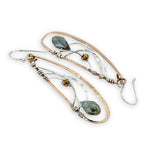 Handmade hammered bronze wings are embellished with sterling silver weaving holding a blue green crystal drop 