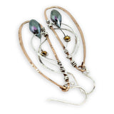 Handmade hammered bronze wings are embellished with sterling silver weaving holding a blue green crystal drop 