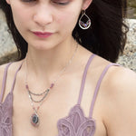 A pair of sterling silver hammered drop earrings with micro faceted pink tourmaline and pyrite gemstones, featuring a pink crystal at the center