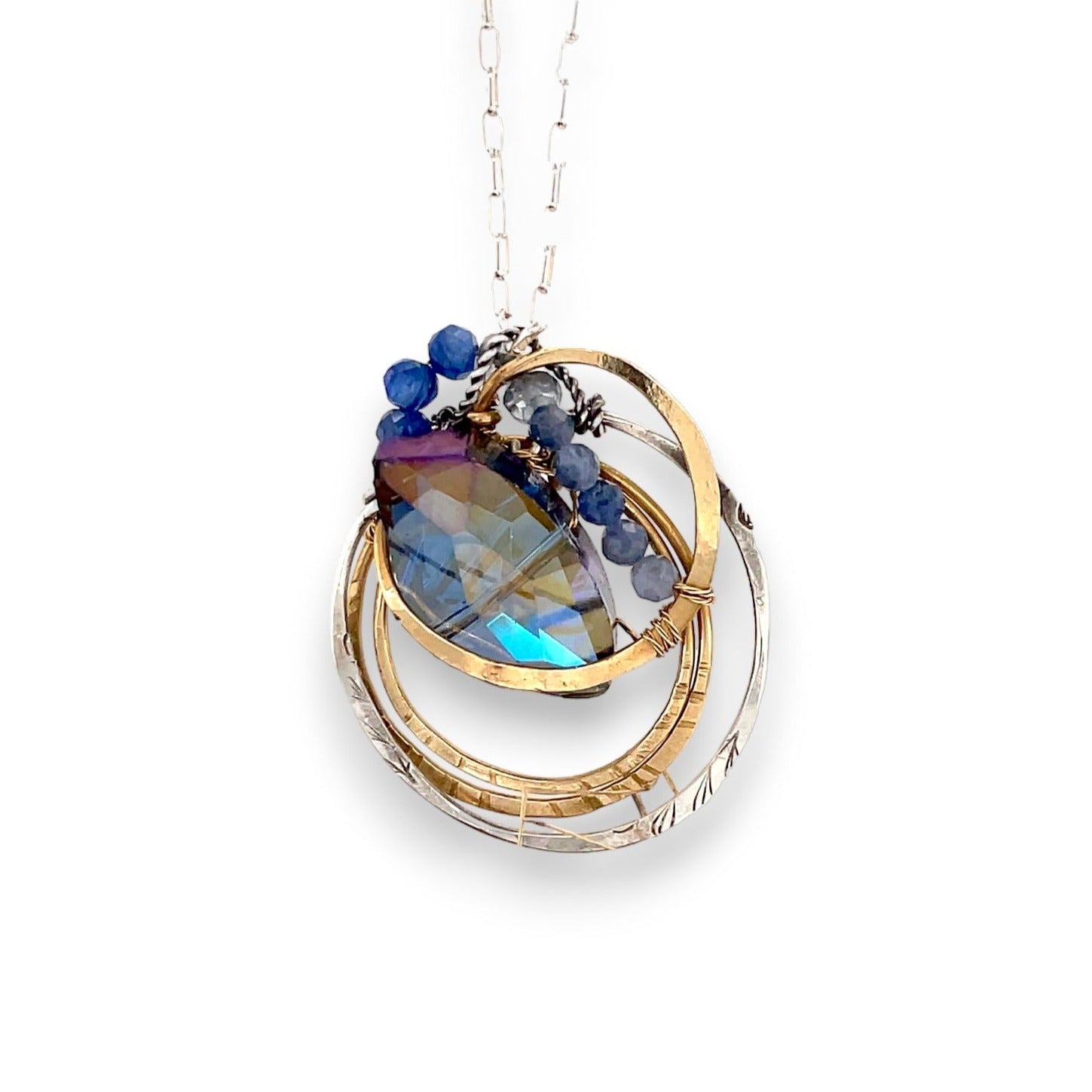 Large blue crystal nestled up in layers of brass and sterling silver nested wire, sodalite gemstones, and brass twist wire accents