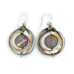 Faceted blue purple crystal coin held inside a nest of oxidized sterling silver wire and thick brass wire earrings