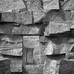 A faceted clear quartz oval gemstone is layered with pyrite and crystals on sterling silver wire inside a bronze parallelogram, then attached to three varying sized parallelograms