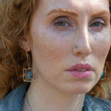 Faceted blue crystal tiles are wrapped tightly in brass twist wire inside a stamped sterling silver box earring, hanging from a gold filled link