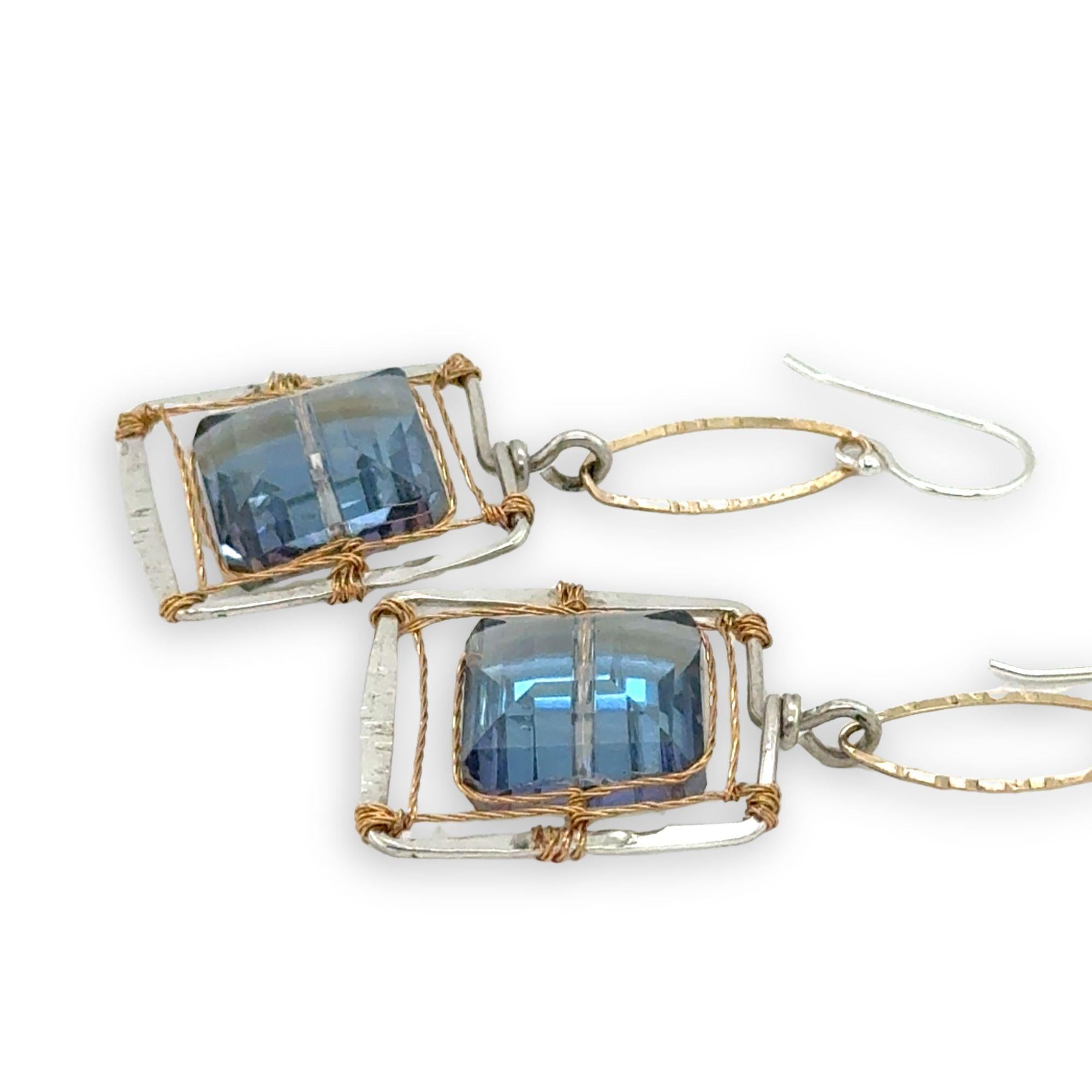 Faceted blue crystal tiles are wrapped tightly in brass twist wire inside a stamped sterling silver box earring, hanging from a gold filled link