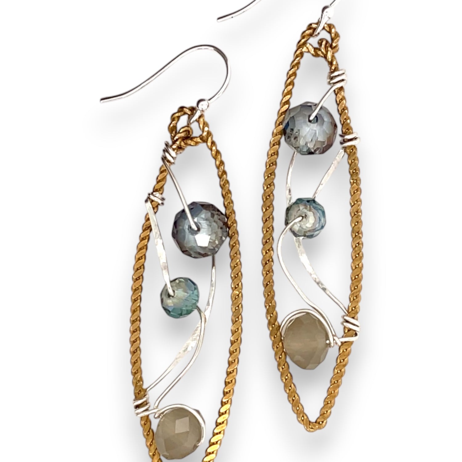 A pair of handmade brass twisted marquise earrings with hammered sterling silver and sparkling crystals in blue, green, and grey colors.
