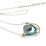 waves of hammered bronze and sterling silver necklace hold a purple-blue crystal coin with chrysocolla and apatite gemstone accentsv