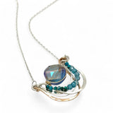 waves of hammered bronze and sterling silver necklace hold a purple-blue crystal coin with chrysocolla and apatite gemstone accents
