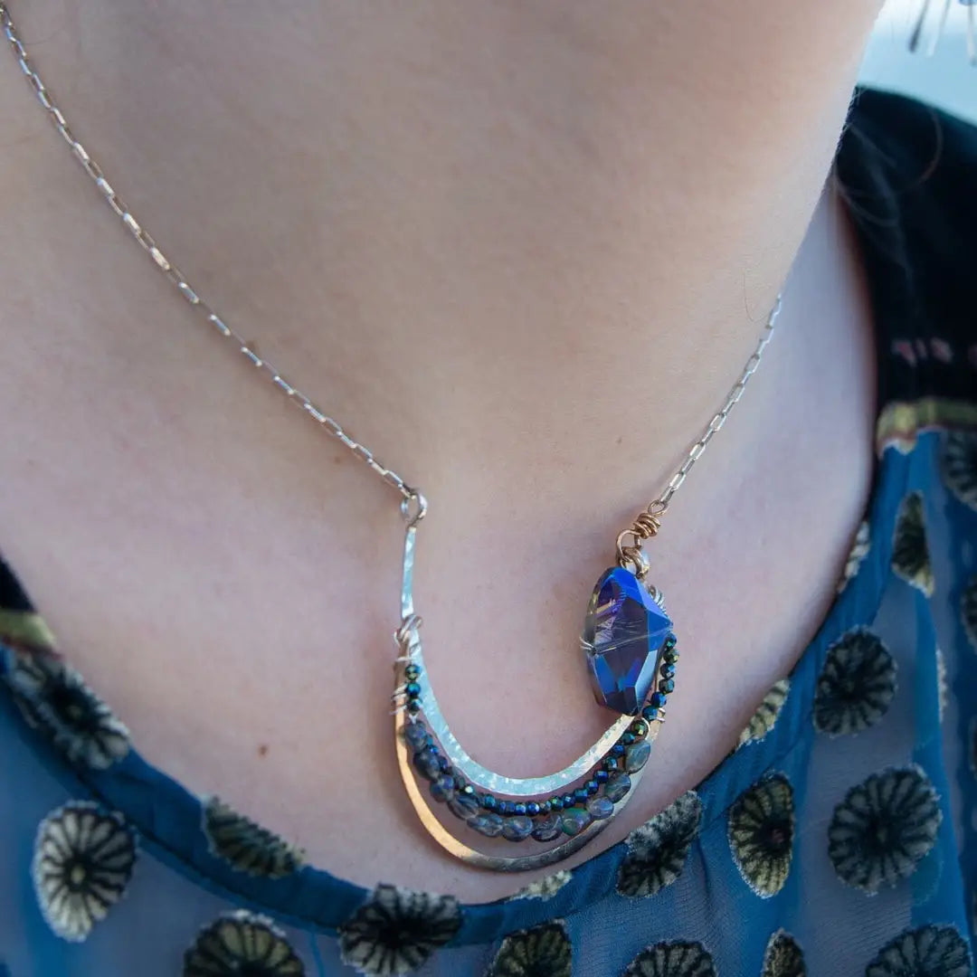 Bronze and sterling silver hammered pendant with blue/purple large crystal with black opal and crystal accents, on a sterling silver box chain necklace