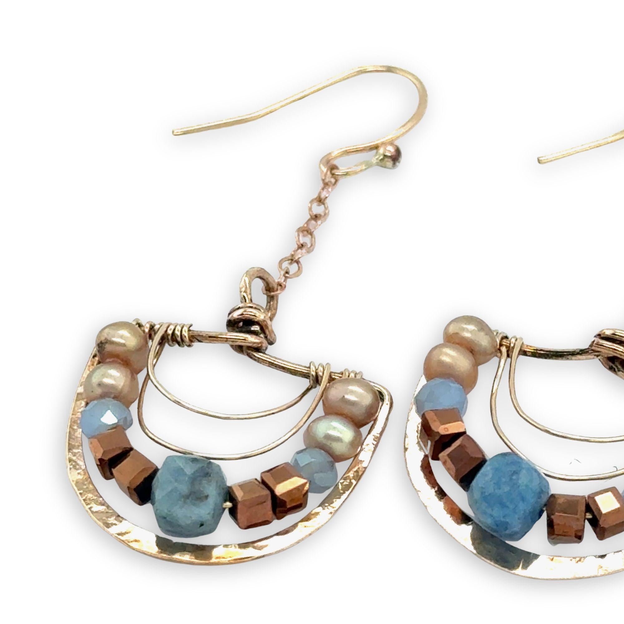 bronze semi circles hanging from find rose gold chain, accented with aquamarine cubes, champagne fresh water pearl, blue crystal and copper crystal cubes