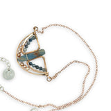 Aquamarine smooth slab is held in the center of a bronze semi circle necklace that's lined with champagne fresh water pearl and aquamarine faceted gemstones on rose gold chain necklace