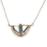 Aquamarine smooth slab is held in the center of a bronze semi circle necklace that's lined with champagne fresh water pearl and aquamarine faceted gemstones on rose gold chain necklace