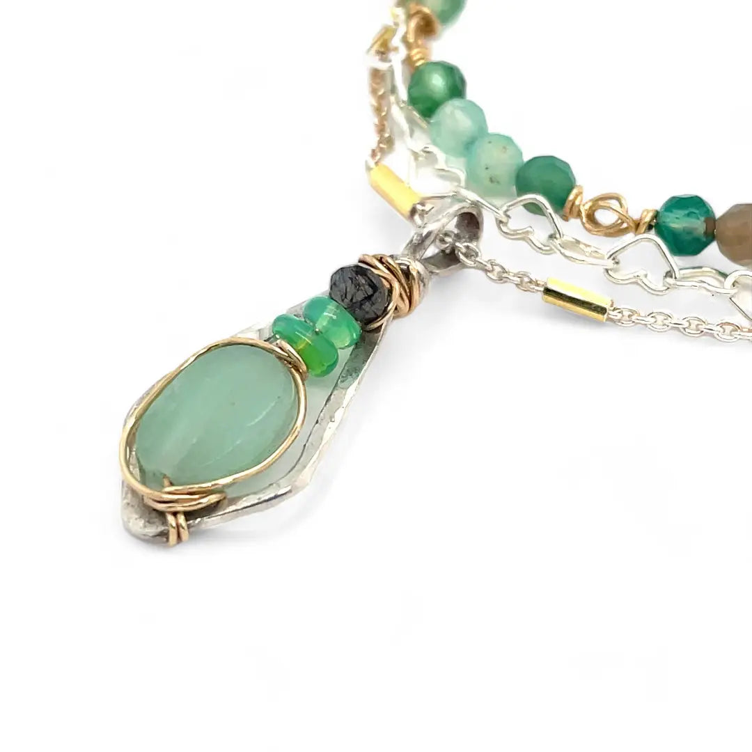 A mini sterling silver pendant with jade and green opal gemstones on gold filled wire hanging from a triple layer chain, with green onyx gemstones, sterling silver heart chain and gold fill accented chain necklace