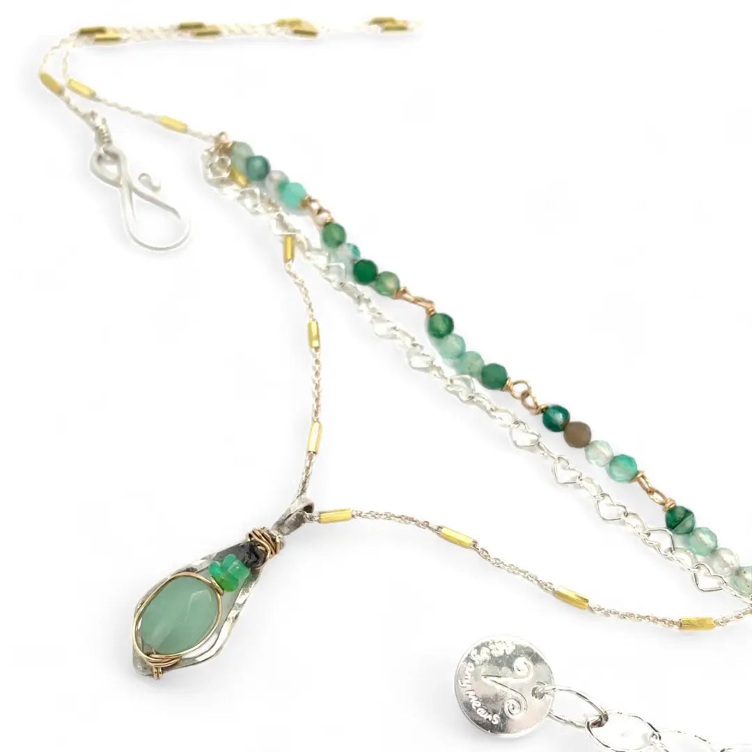A mini sterling silver pendant with jade and green opal gemstones on gold filled wire hanging from a triple layer chain, with green onyx gemstones, sterling silver heart chain and gold fill accented chain necklace