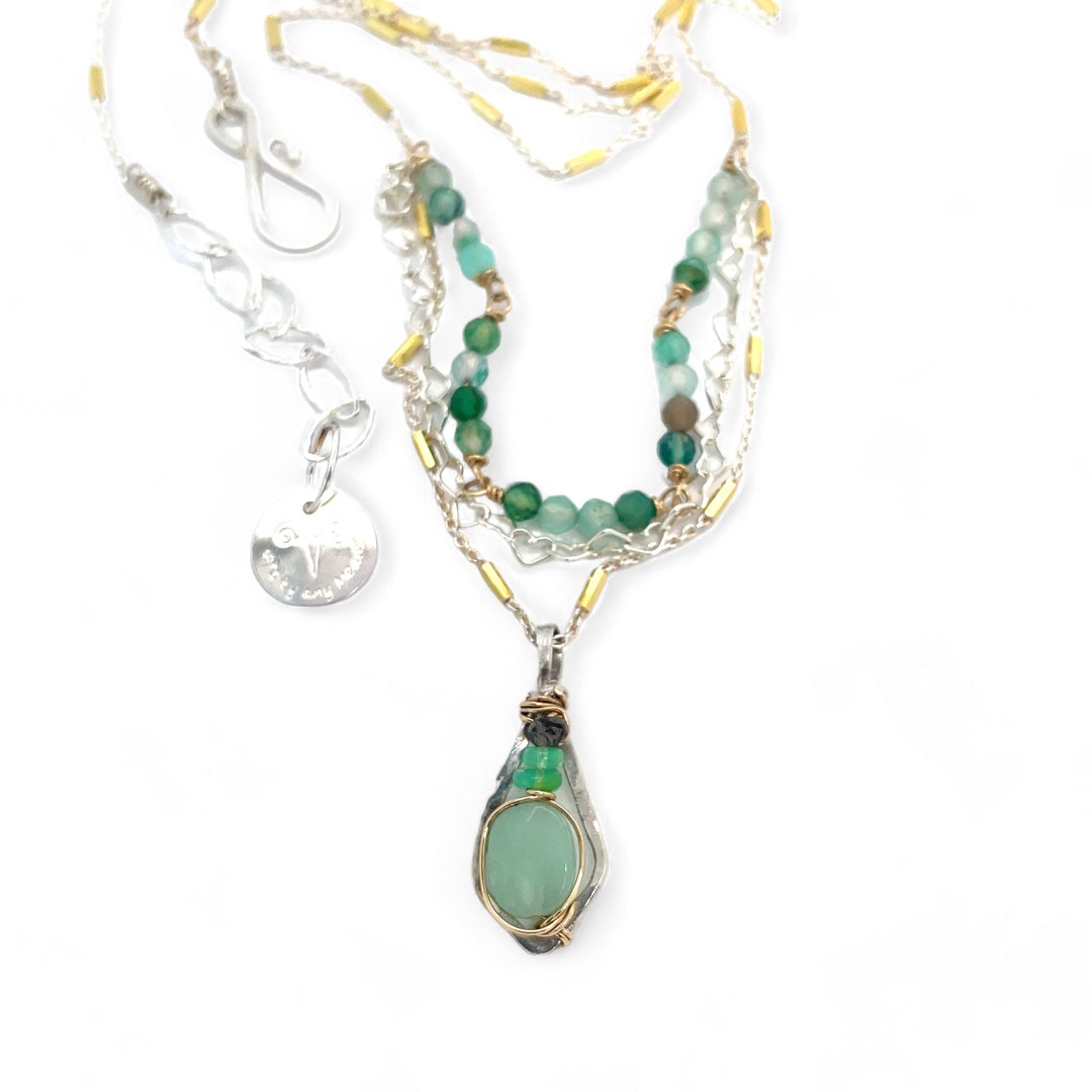 A mini sterling silver pendant with jade and green opal gemstones on gold filled wire hanging from a triple layer chain, with green onyx gemstones, sterling silver heart chain and gold fill accented chain necklace