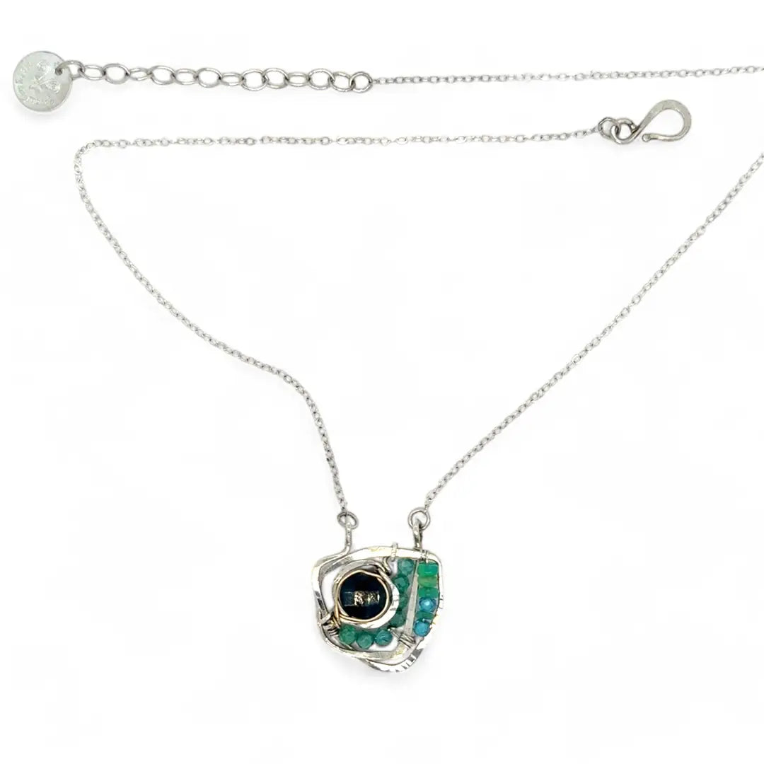 A sterling silver necklace with a faceted dark teal apatite coin set in gold fill centers, surrounded by cubic zirconia and green opal gemstones, with a mini sterling silver clasp.