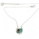 A sterling silver necklace with a faceted dark teal apatite coin set in gold fill centers, surrounded by cubic zirconia and green opal gemstones, with a mini sterling silver clasp.