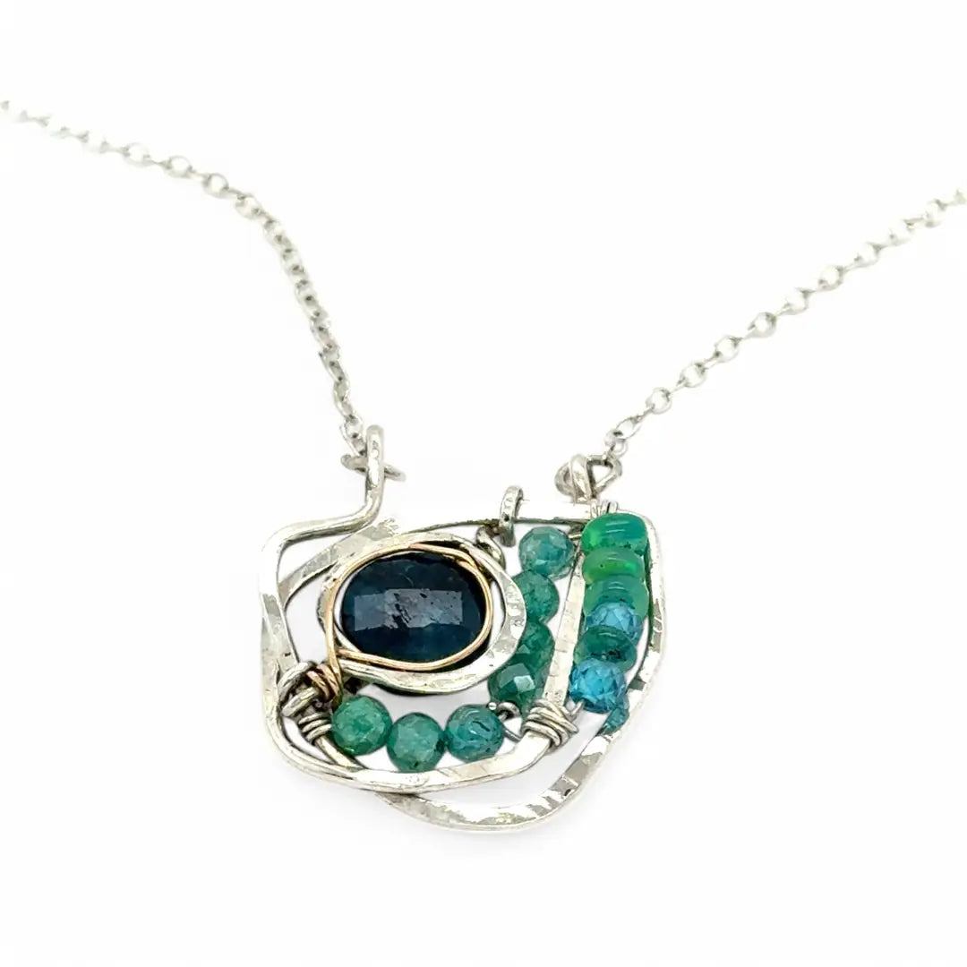 A sterling silver necklace with a faceted dark teal apatite coin set in gold fill centers, surrounded by cubic zirconia and green opal gemstones, with a mini sterling silver clasp.