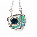 A sterling silver necklace with a faceted dark teal apatite coin set in gold fill centers, surrounded by cubic zirconia and green opal gemstones, with a mini sterling silver clasp.