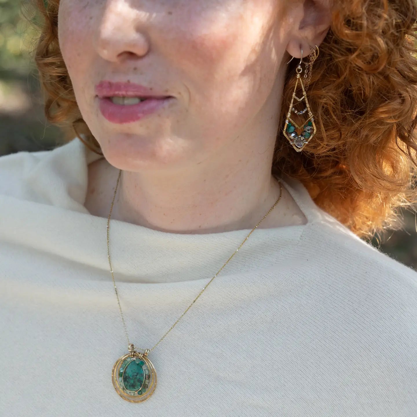 A brass triple circle necklace with turquoise and green fluorite faceted gemstones, featuring an adjustable gold-filled and sterling silver chain 