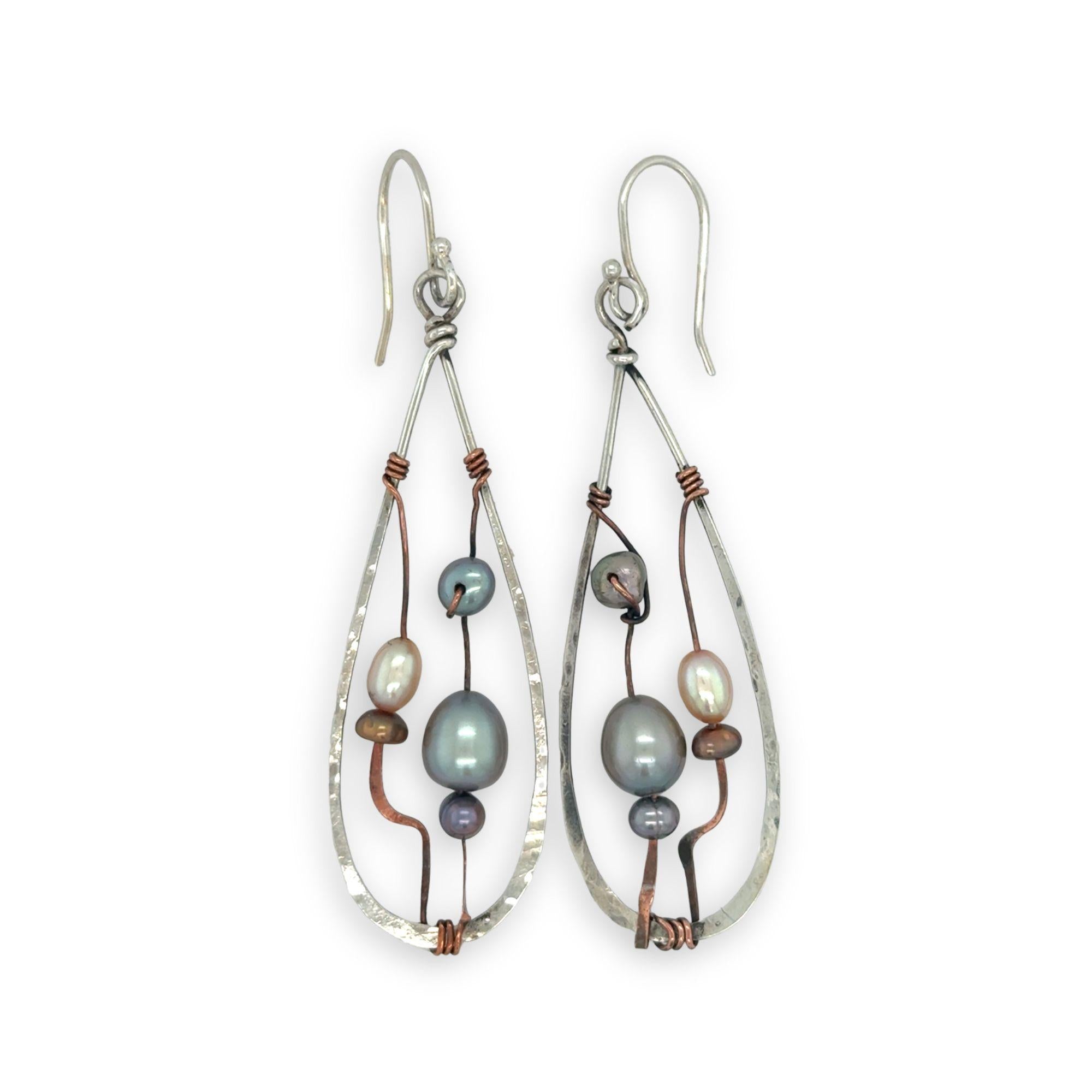 Variety of blue, purple, cream and rust fresh water pearls wrapped in hammered copper wire held onto a sterling silver drop earring