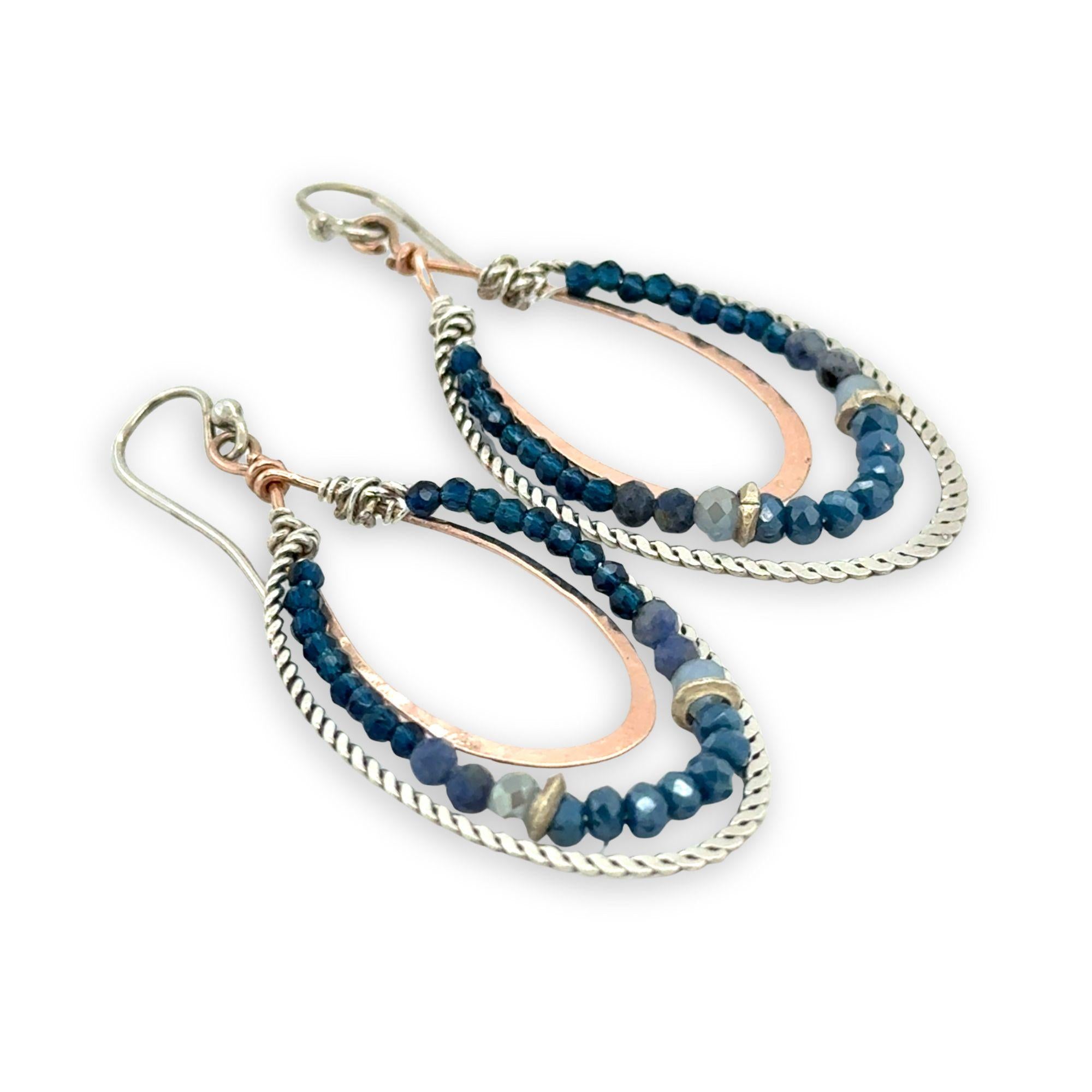 Blue crystal, sodalite, and rich blue quartz gemstones are set between bronze hammered drops and hammered oxidized sterling silver twist earrings