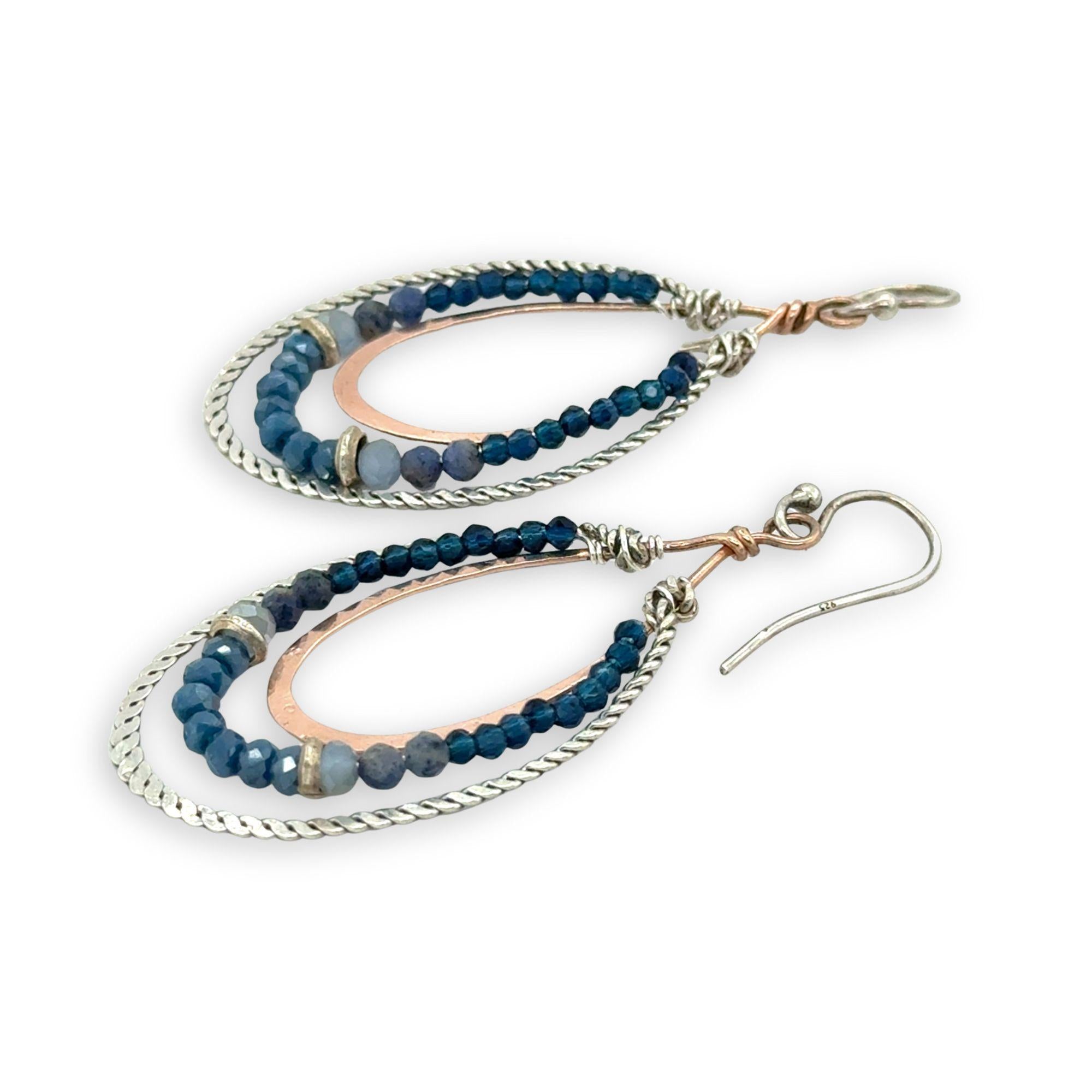 Blue crystal, sodalite, and rich blue quartz gemstones are set between bronze hammered drops and hammered oxidized sterling silver twist earrings