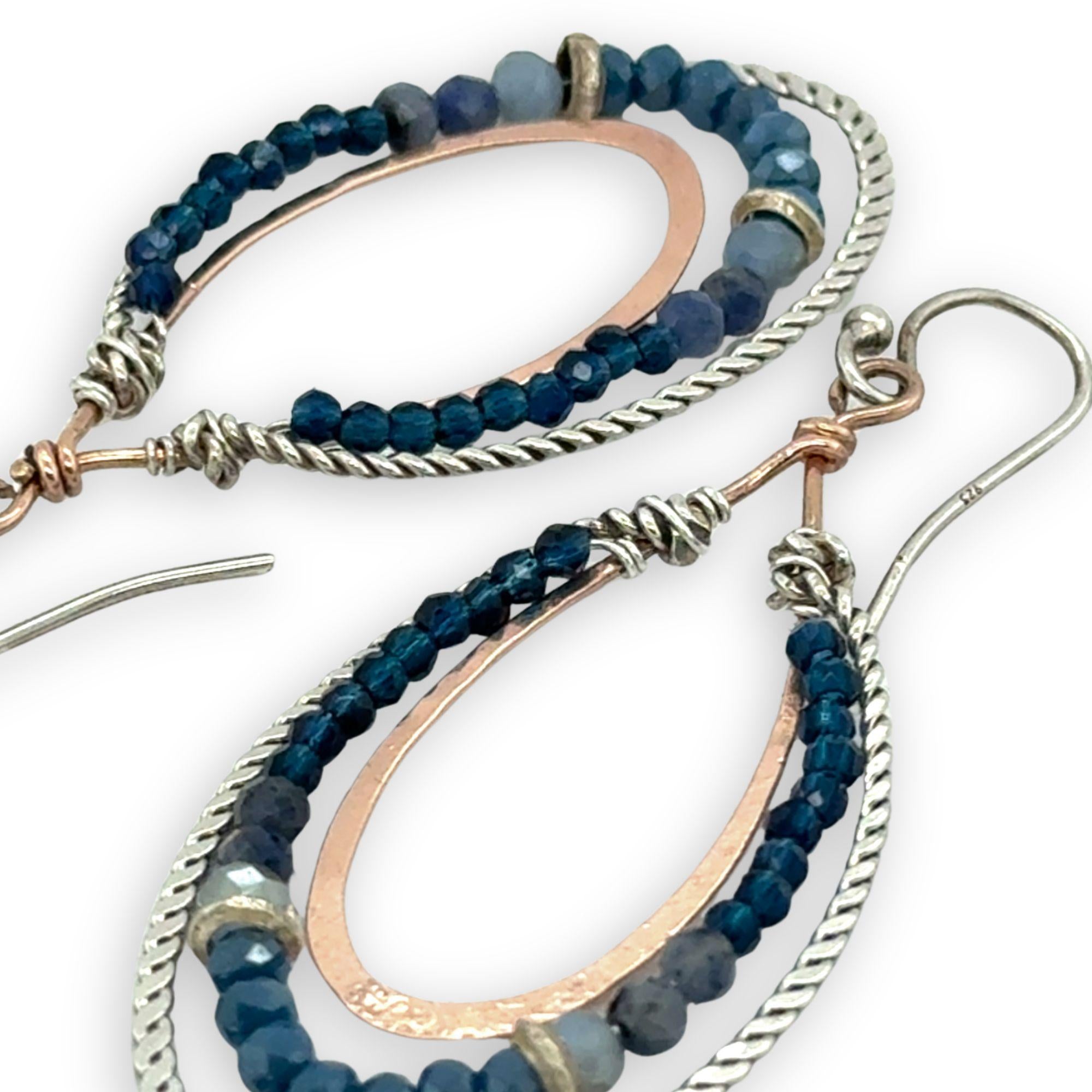 Blue crystal, sodalite, and rich blue quartz gemstones are set between bronze hammered drops and hammered oxidized sterling silver twist earrings