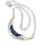 Silver necklace with a crescent moon-shaped pendant featuring blue kyanite cubes and lapis faceted gemstones on heart chain sterling silver chain necklace