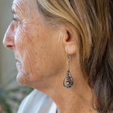 A pair of sterling silver teardrop earrings hang from curb link chain with blue/purple fresh water pearls and sodalite gemstone accents