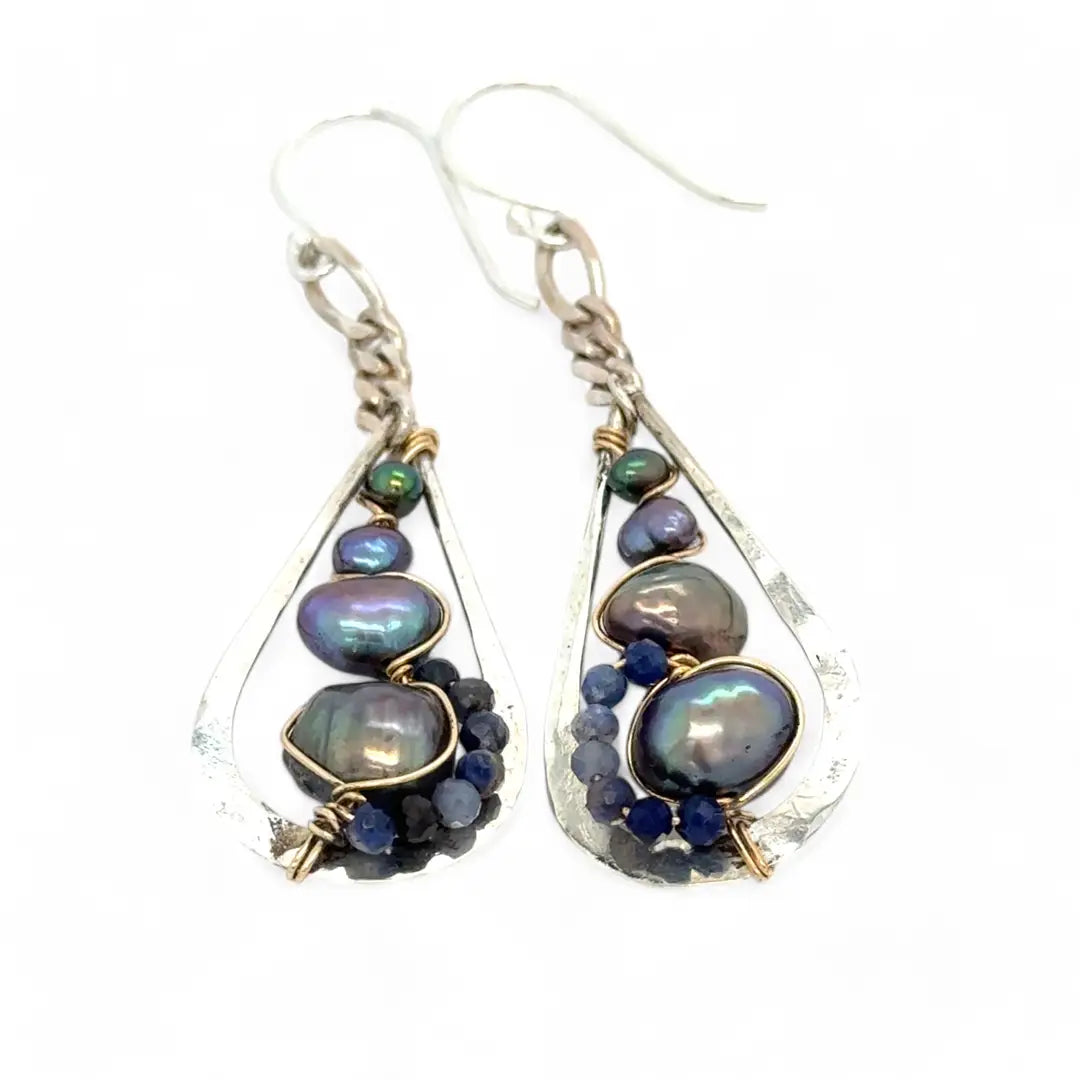 A pair of sterling silver teardrop earrings hang from curb link chain with blue/purple fresh water pearls and sodalite gemstone accents