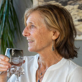 A pair of sterling silver teardrop earrings hang from curb link chain with blue/purple fresh water pearls and sodalite gemstone accents