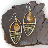 Smooth citrine nuggets hang above layers of green and orange crystal and luminescent citrine gemstones within a handmade hammered brass drop earrings