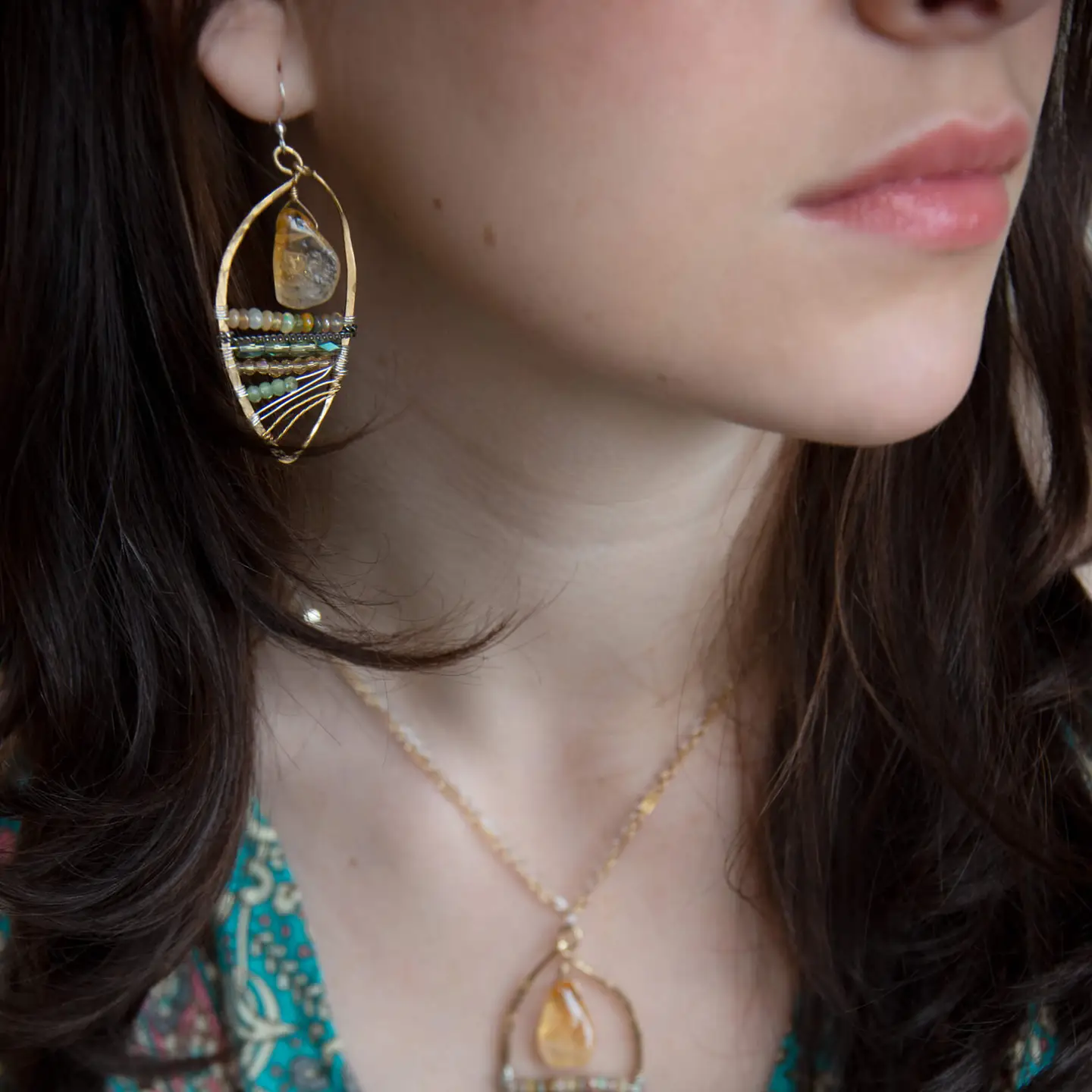 Smooth citrine nuggets hang above layers of green and orange crystal and luminescent citrine gemstones within a handmade hammered brass drop earrings