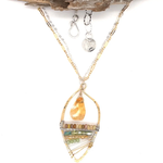 Smooth citrine drop hangs above layers of green crystal and orange crystal and luminescent citrine gemstones inside a hammered handmade brass drop necklace on sterling silver and gold filled doubled up chain