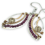 Earrings with gold, silver, and garnet bead details on a white background