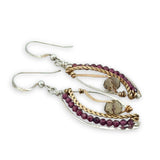 Pair of earrings with gold, silver, and garnet beads on a white background