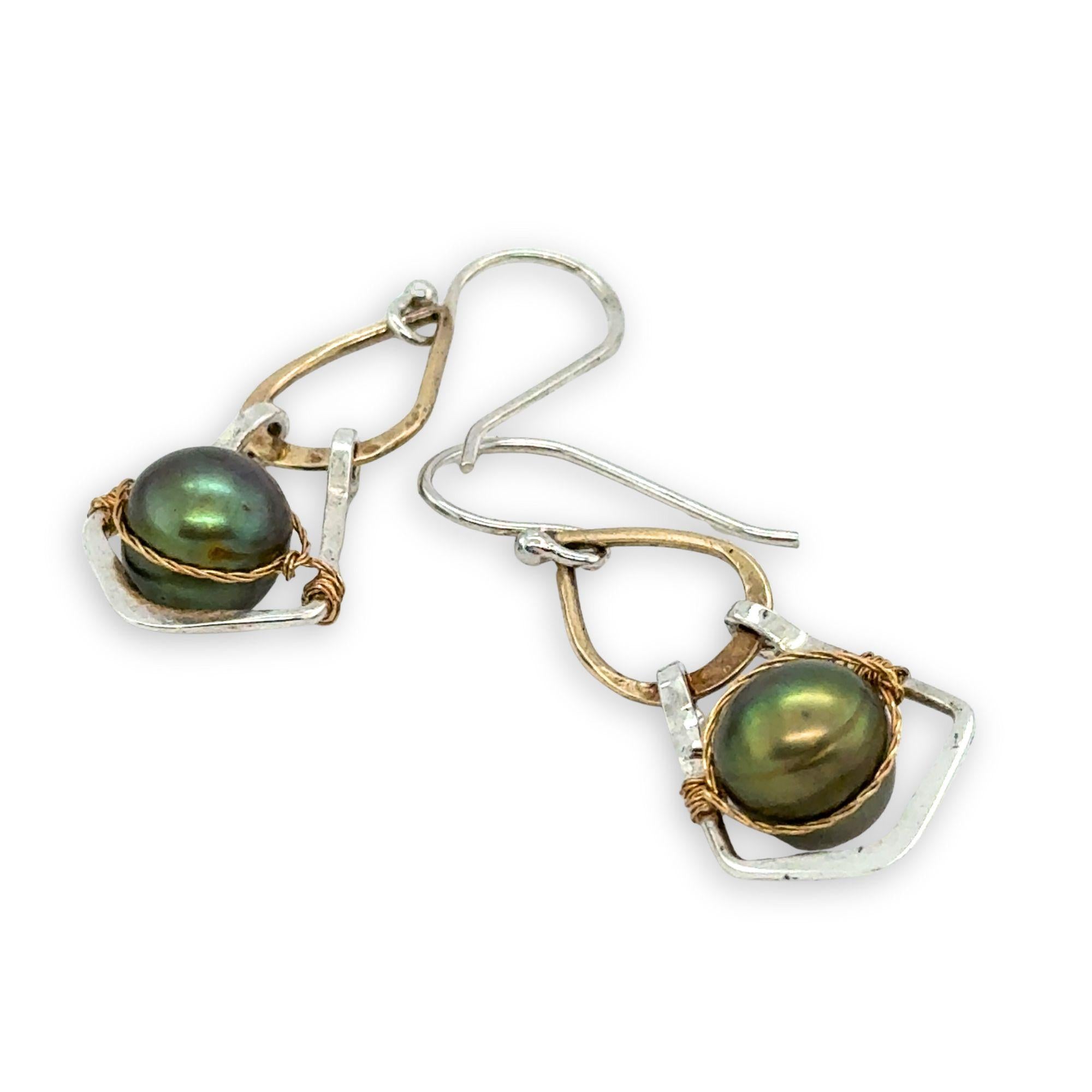 Pair of earrings with green pearls and gold and silver wirework on a white background