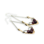 Two drop earrings featuring red garnet gemstones on a white background.