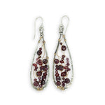 Teardrop-shaped earrings with garnet beads and gold wirework on a white background