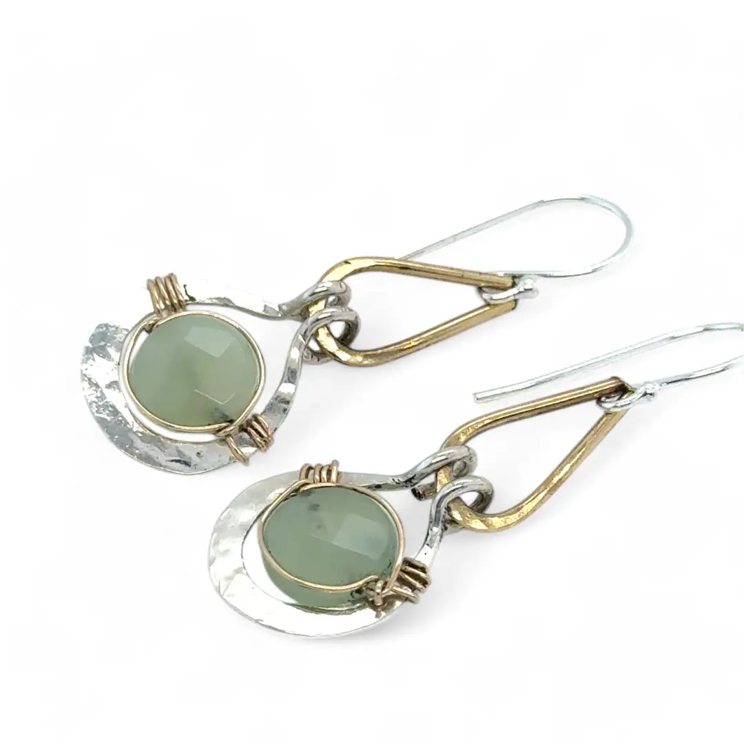 Pair of earrings with green jade gemstones and gold and silver accents on a white background