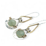 Pair of earrings with green jade gemstones and gold and silver accents on a white background