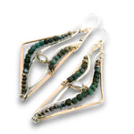 A pair of handmade geometric dangle earrings featuring triangular gold-plated wire frames, lined with dark green and black faceted beads, and accented with a small white pearl and a central gold bezel setting.