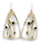 A pair of gold geometric dangle earrings with thin wire frames and small dark green and olive bead accents, shown against a plain white background.