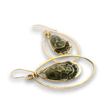 A pair of gold dangle earrings featuring organic-shaped gold wire loops and oval bezel settings holding dark green marbled stone beads, shown on a white background.