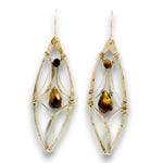 A pair of gold wire-wrapped dangle earrings with teardrop-shaped brown and amber stones, shown against a plain white background.