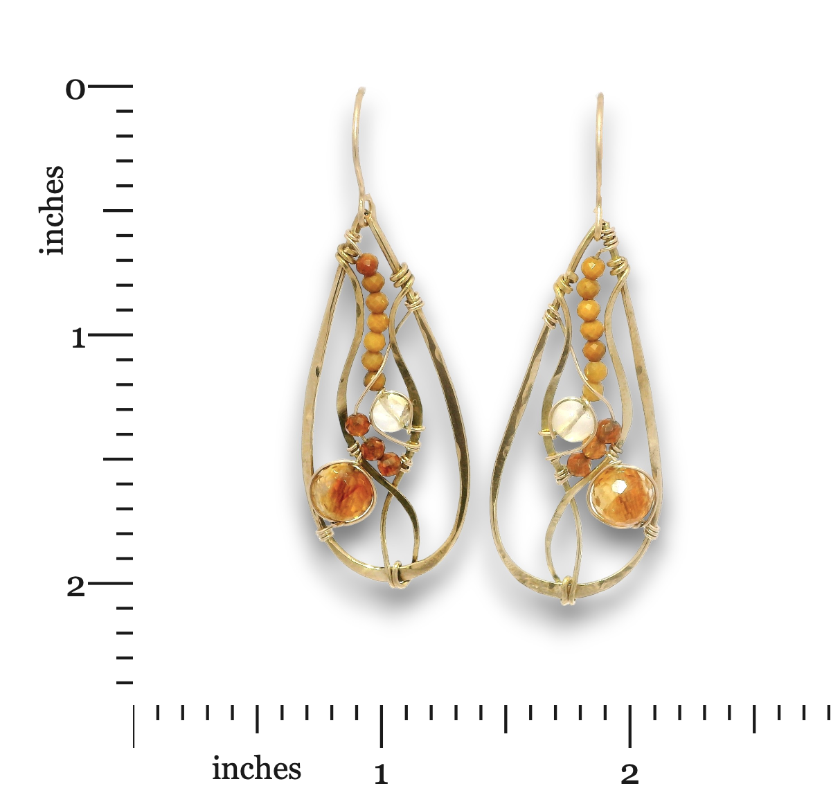 A pair of gold teardrop dangle earrings with amber and glass bead details, shown next to a black measurement ruler on a white background.