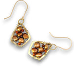 A pair of gold-toned dangle earrings featuring irregular brown and bronze baroque pearls wrapped in textured wire, with small orange-red accent beads, shown on a white background.