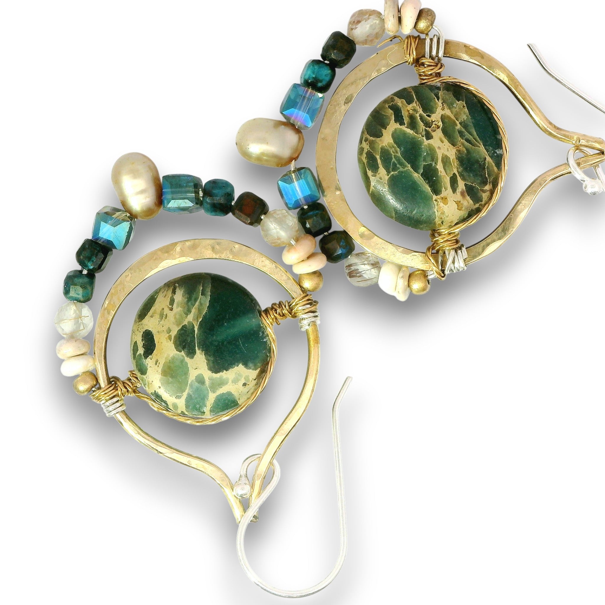A pair of gold hoop earrings featuring round green marbled stone centers, accented with small faceted beads in teal, blue, brown, and cream on a white background.